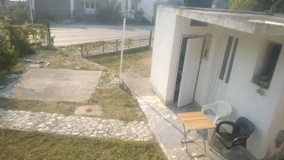 a balcony with a table and chairs next to a building at Filipova vikendica in Peroči