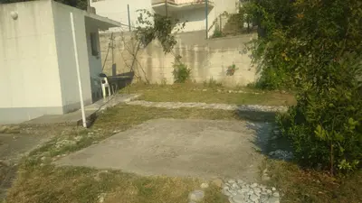 an empty yard next to a white building at Filipova vikendica in Peroči