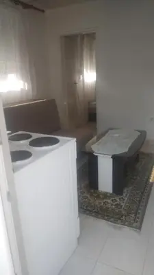 a kitchen with a stove and a table in a room at Filipova vikendica in Peroči
