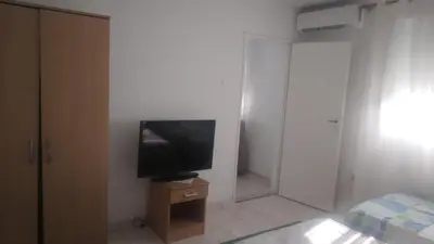 a room with a television on a dresser in a bedroom at Filipova vikendica in Peroči