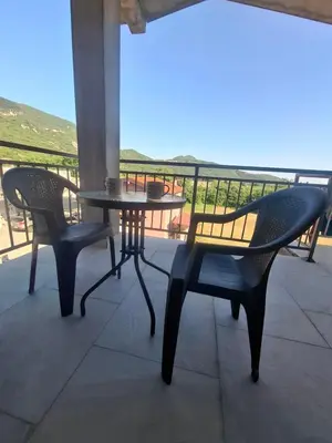 a table and chairs on a balcony with a view of the ocean at Apartman Andjela 2 in Budva