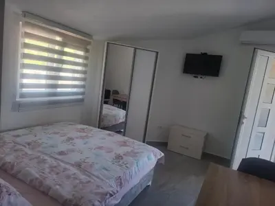 a bedroom with a bed and a flat screen tv at Apartman Andjela 2 in Budva