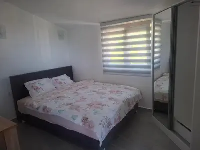 a bedroom with a bed and a window with blinds at Apartman Andjela 2 in Budva