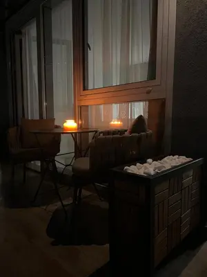 a living room with a table and a chair and two candles at Apartmani Vanity Budva in Budva