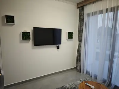 a flat screen tv on a white wall with a window at Etno Lux Isaković in Ulcinj