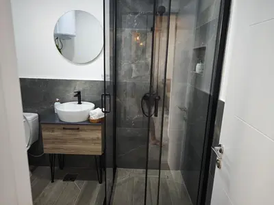 a bathroom with a shower with a sink and a mirror at Etno Lux Isaković in Ulcinj