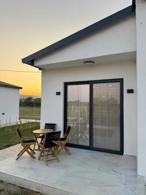 a patio with a table and chairs and a building at Etno Lux Isaković in Ulcinj
