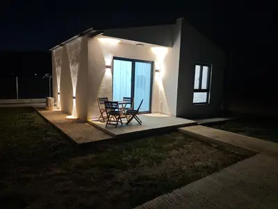 a table and chairs sitting on a patio at night at Etno Lux Isaković in Ulcinj