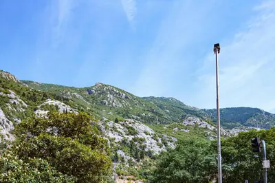 a street light in front of a mountain at Brazos Apartment in Kotor