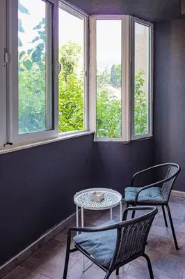 a room with two chairs and a table and two windows at Brazos Apartment in Kotor