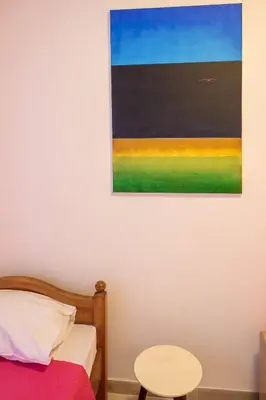 a painting hanging on a wall next to a bed at Brazos Apartment in Kotor