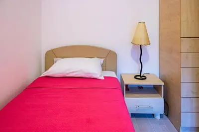 a bedroom with a bed with a red blanket and a lamp at Brazos Apartment in Kotor
