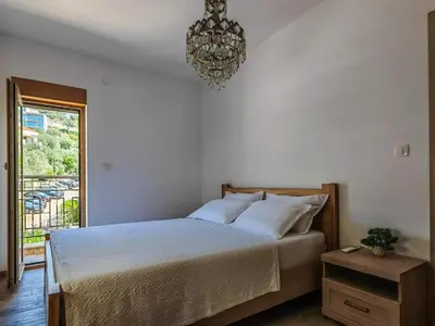 a bedroom with a bed and a chandelier at Adriatic Escape -Modern Sea View Apartment,Special Summer Deal in Pržno