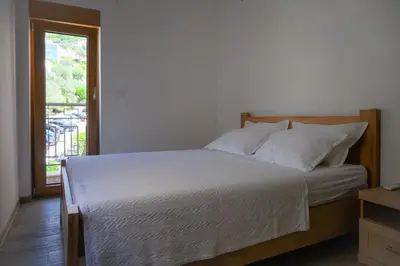 a bedroom with a large bed with white sheets and a window at Adriatic Escape -Modern Sea View Apartment,Special Summer Deal in Pržno