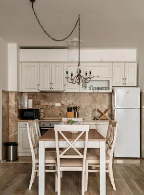 a kitchen with a table and a white refrigerator at Adriatic Escape -Modern Sea View Apartment,Special Summer Deal in Pržno
