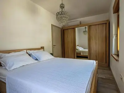 a bedroom with a large white bed with a chandelier at Adriatic Escape -Modern Sea View Apartment,Special Summer Deal in Pržno