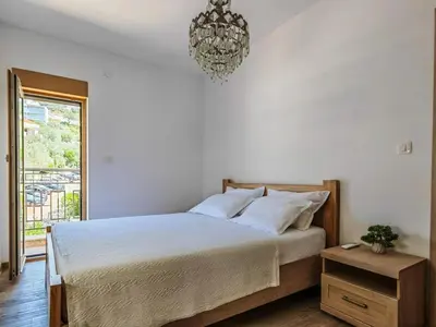 a bedroom with a bed and a chandelier at Adriatic Escape -Modern Sea View Apartment,Special Summer Deal in Pržno