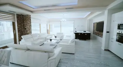 a white living room with white couches and a tv at Apartment Matej 2 in Budva