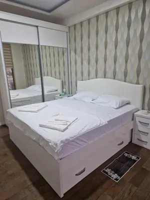 a bedroom with a large white bed and a mirror at Apartment Matej 2 in Budva