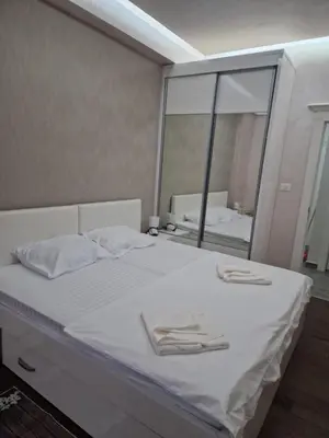 a bedroom with a white bed with a large mirror at Apartment Matej 2 in Budva