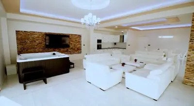 a large white room with white chairs and a fireplace at Apartment Matej 2 in Budva