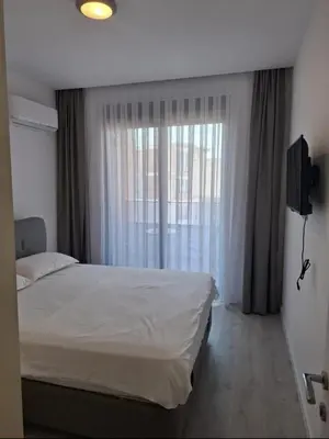 a bedroom with a white bed and a window at Violin Apartment in Ulcinj