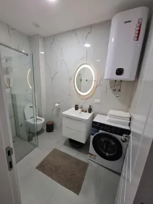 a white bathroom with a sink and a washing machine at Violin Apartment in Ulcinj