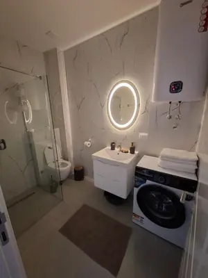 a bathroom with a sink and a washing machine at Violin Apartment in Ulcinj