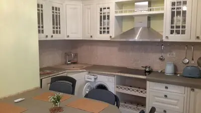 a kitchen with white cabinets and a washer at Glorious in Kotor