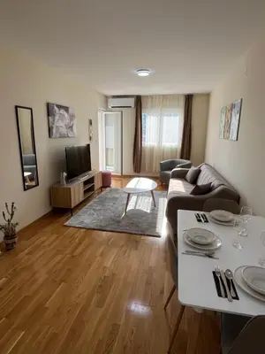 a living room with a couch and a table at Dora apartment with terrace and parking in Podgorica