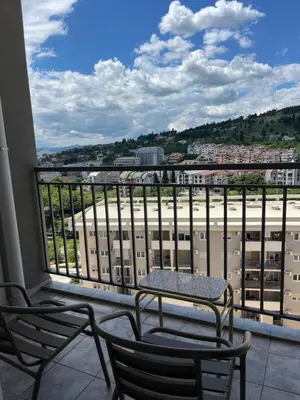 a balcony with a table and chairs and a view at Dora apartment with terrace and parking in Podgorica