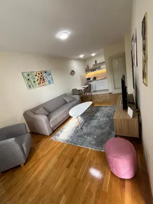 a living room with a couch and a table at Dora apartment with terrace and parking in Podgorica