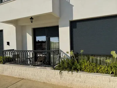 a balcony with black blinds on a house at Harmony Apartment 2 in Bar