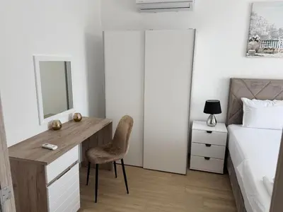 a bedroom with a desk and a bed and a mirror at Apartments Paris in Donji Štoj