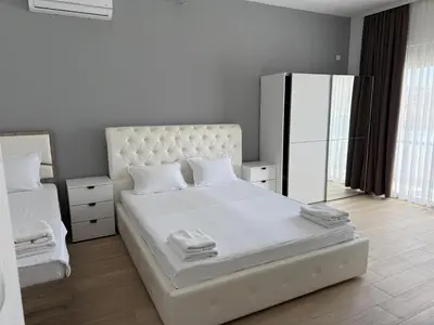 a bedroom with a large white bed and a mirror at Apartments Paris in Donji Štoj