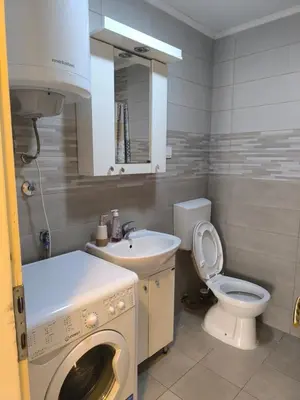 a bathroom with a washing machine and a sink at TriKula Nest in Bar