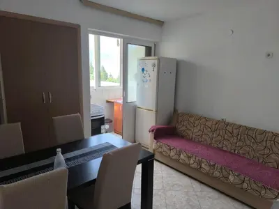 a kitchen with a couch and a table and a refrigerator at TriKula Nest in Bar