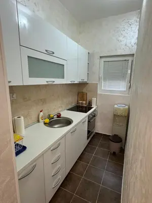 a small kitchen with white cabinets and a sink at Apartman Itana Budva in Budva