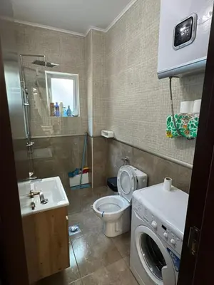 a bathroom with a toilet and a sink and a washing machine at Apartman Itana Budva in Budva