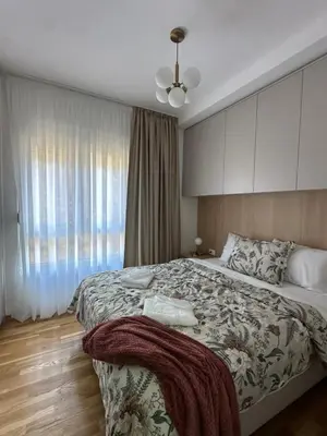 a bedroom with a large bed and a window at Modern Apartments Two Pearls in Budva