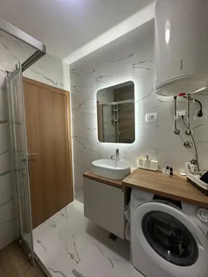 a bathroom with a washing machine and a sink at Modern Apartments Two Pearls in Budva