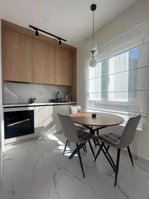 a kitchen with a wooden table and chairs in a kitchen at Modern Apartments Two Pearls in Budva