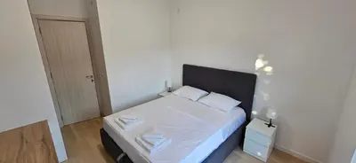 a small bedroom with a bed with white sheets at ROYAL Residences in Cetinje