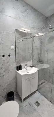 a white bathroom with a sink and a shower at ROYAL Residences in Cetinje