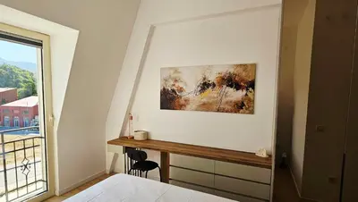a bedroom with a desk and a painting on the wall at ROYAL Residences in Cetinje