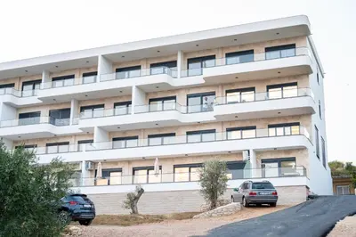 an apartment building with cars parked in front of it at sea and sun luxury apartment in Ulcinj