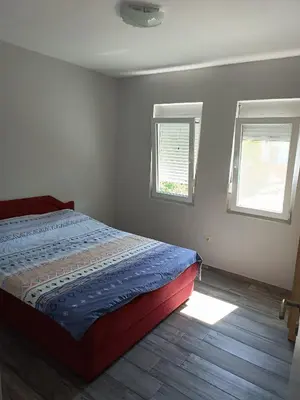 a bedroom with a bed and two windows at Infinite Sunset in Ulcinj