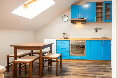 a kitchen with blue cabinets and a table and chairs at Bay View Apartment in Kotor