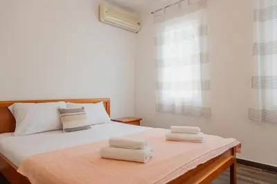 a bedroom with a bed with two towels on it at Bay View Apartment in Kotor