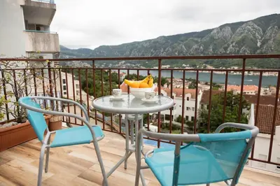 a table and two chairs on a balcony with a view at Bay View Apartment in Kotor